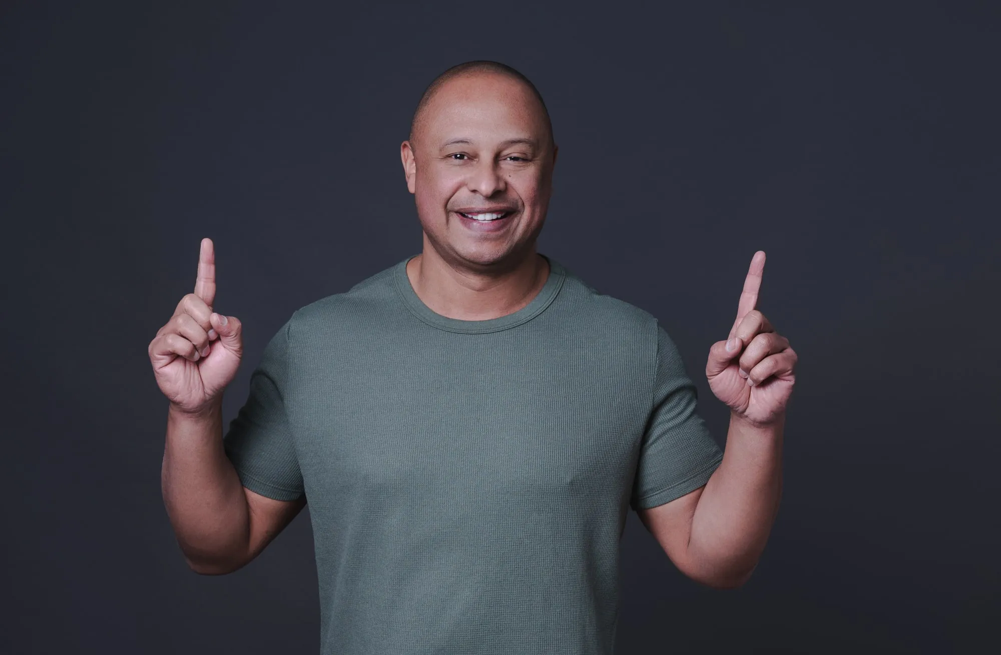 Professor Almir Vieira sorrindo e apontando para cima, comemorando